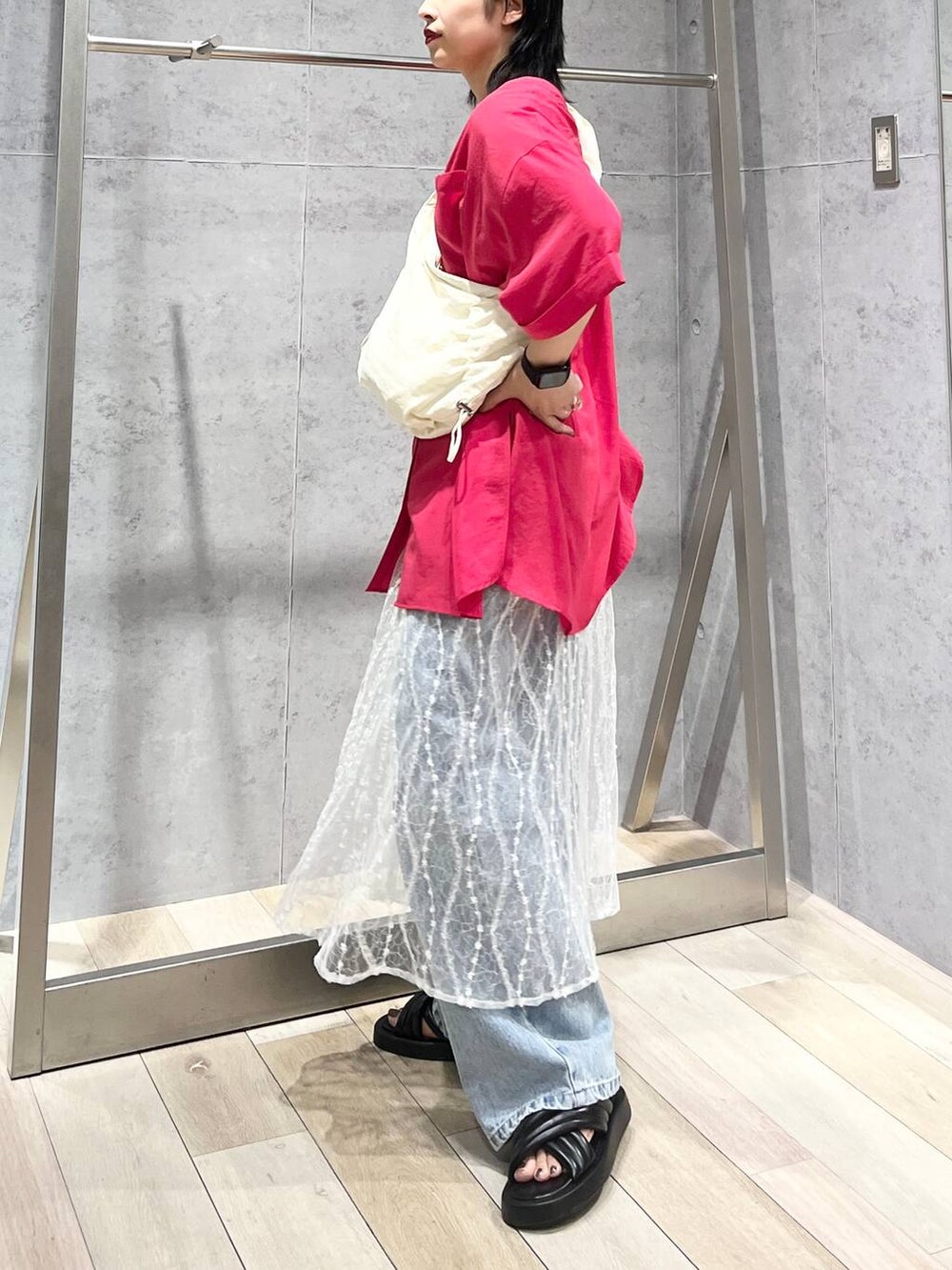 ブラック系のサンダル、ブルー系のデニムパンツ、ホワイト系のスカートを着用したレディースの夏コーディネートの4枚目の写真