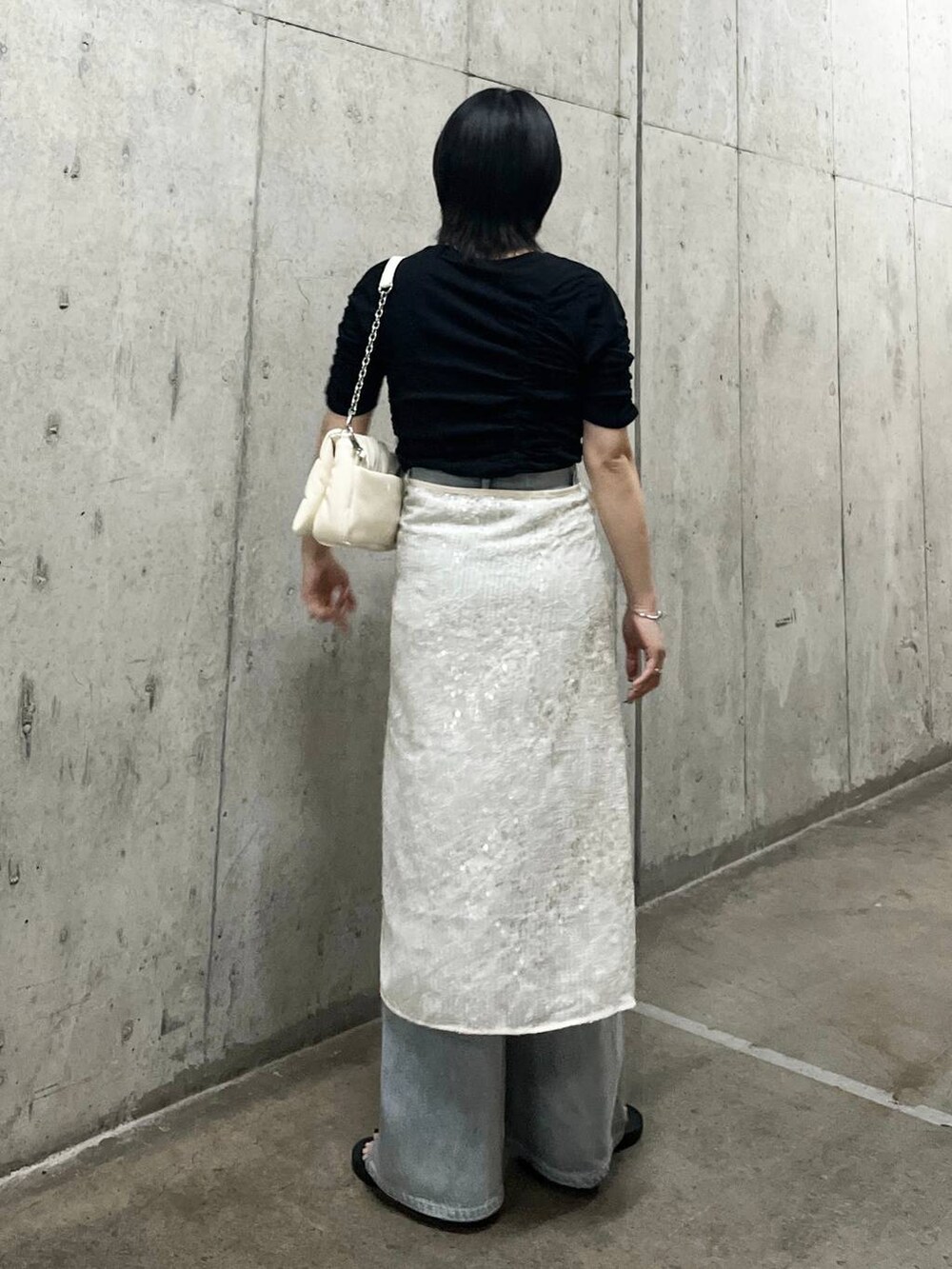 ホワイト系のショルダーバッグ、ブルー系のデニムパンツ、ブラック系のTシャツ/カットソーを着用したレディースの春コーディネートの4枚目の写真