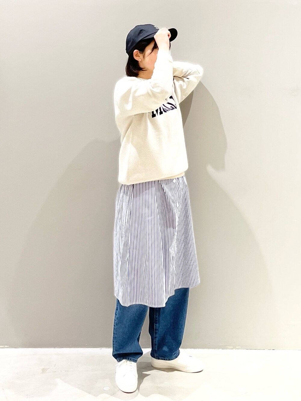ホワイト系のニット/セーター、ブルー系のデニムパンツ、ホワイト系のスニーカーを着用したレディースの冬コーディネートの4枚目の写真