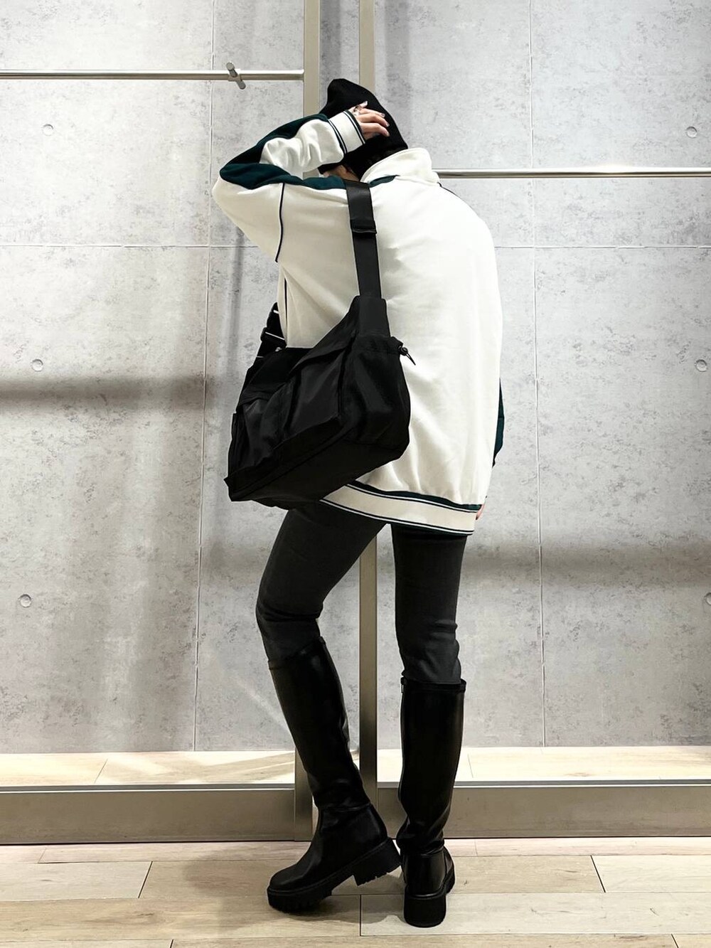 ホワイト系のTシャツ/カットソー、ブラック系のブーツ、グレー系のデニムパンツを着用したレディースの冬コーディネートの6枚目の写真