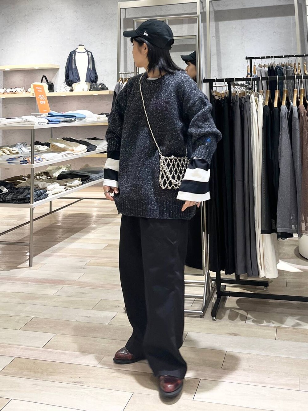 シルバー系のショルダーバッグ、グレー系のチノパンツ、ブラック系のTシャツ/カットソーを着用したレディースの秋コーディネートの5枚目の写真