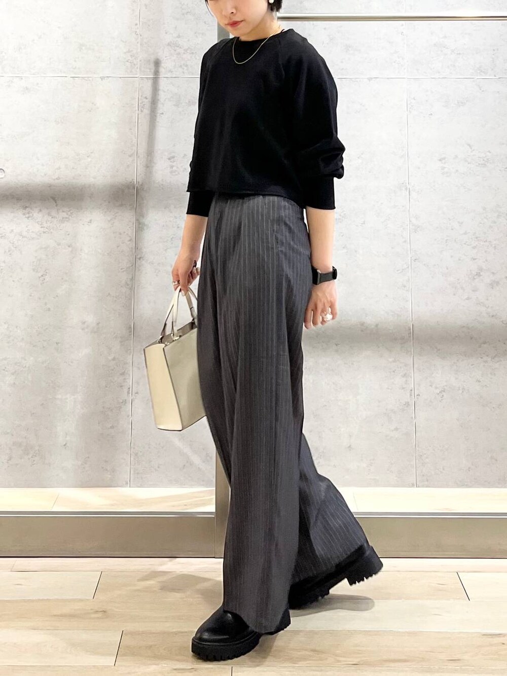 ブラック系のTシャツ/カットソー、ホワイト系のショルダーバッグ、グレー系のその他パンツを着用したレディースの秋コーディネートの7枚目の写真