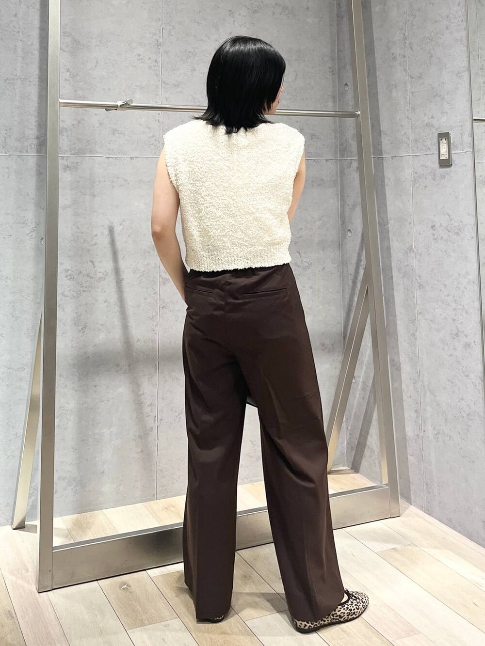 ブラック系のボストンバッグ、その他のバレエシューズ、ホワイト系のベストを着用したレディースの秋コーディネートの2枚目の写真