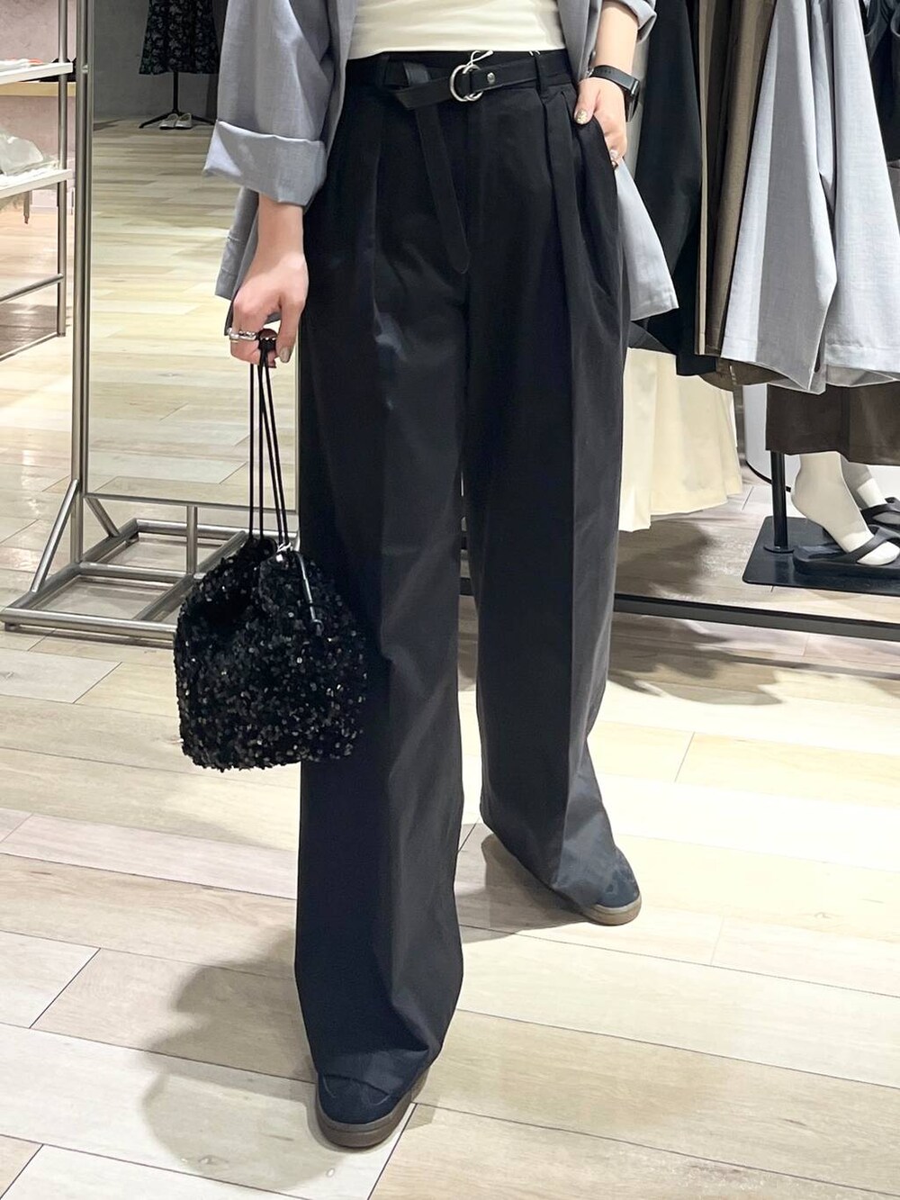 グレー系のチノパンツ、ブラック系のスニーカー、ホワイト系のキャミソールを着用したレディースの秋コーディネートの4枚目の写真