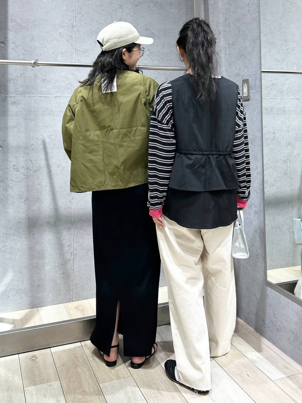 ブラック系のスカート、ホワイト系のショルダーバッグ、ブラック系のサンダルを着用したレディースの春コーディネートの3枚目の写真