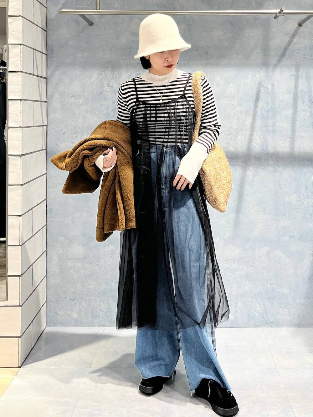 ブラウン系のブルゾン、ブラック系のモカシン/デッキシューズ、ゴールド系のショルダーバッグを着用したレディースの冬コーディネートの8枚目の写真