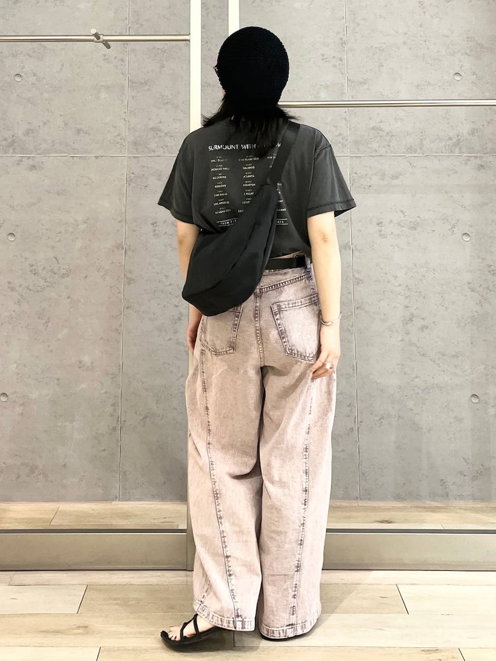 パープル系のデニムパンツ、ブラック系のショルダーバッグ、ブラック系のTシャツ/カットソーを着用したレディースの春コーディネートの6枚目の写真