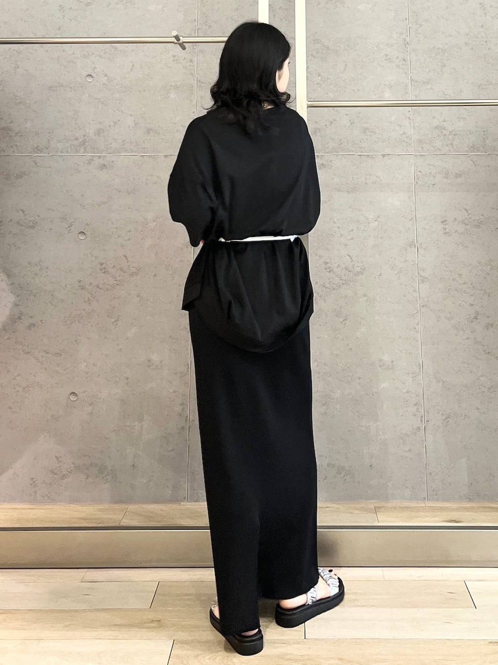 ブラック系のスカート、ブラック系のTシャツ/カットソー、シルバー系のサンダルを着用したレディースの春コーディネートの4枚目の写真