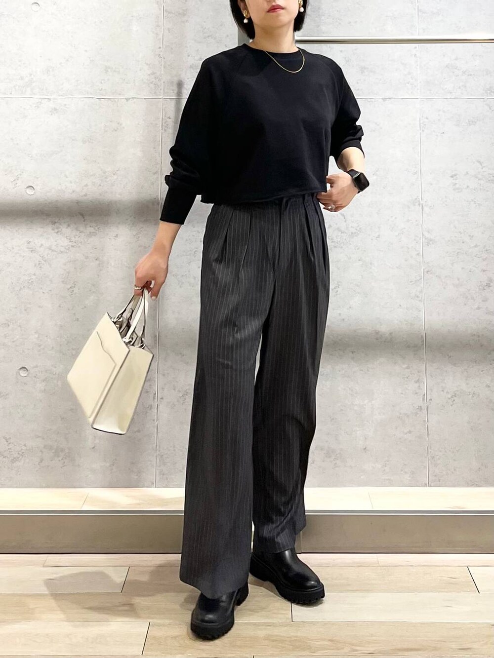 ブラック系のTシャツ/カットソー、ホワイト系のショルダーバッグ、グレー系のその他パンツを着用したレディースの秋コーディネートの2枚目の写真