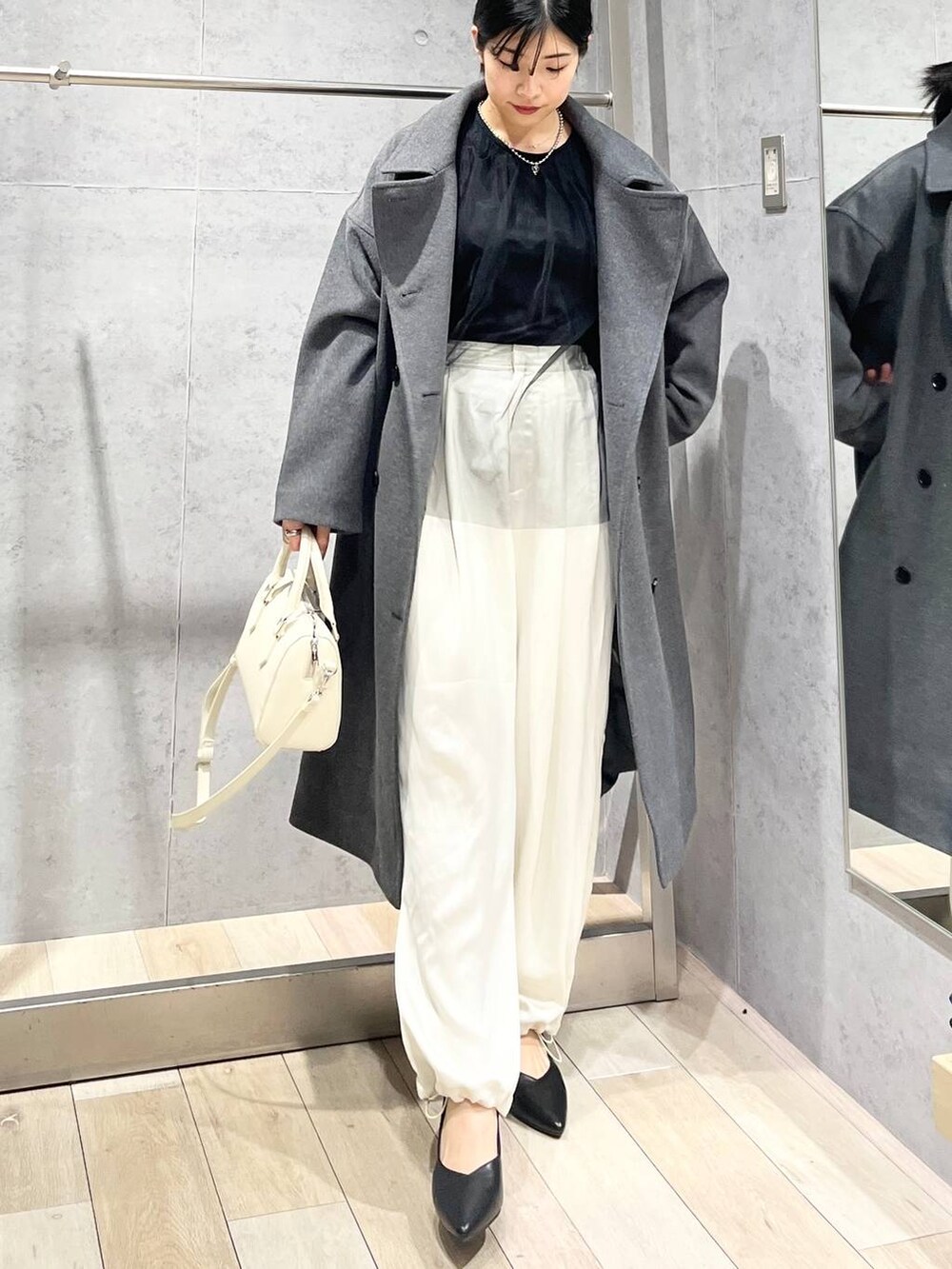 グレー系のその他アウター、ブラック系のTシャツ/カットソー、ブラック系のパンプスを着用したレディースの冬コーディネートの2枚目の写真