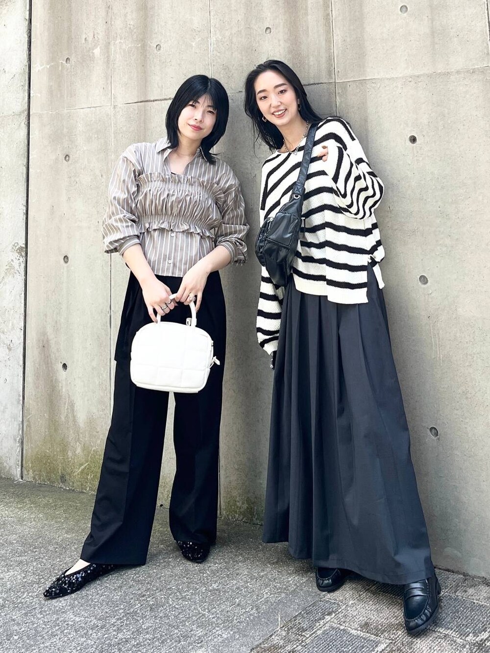 ブラック系のニット/セーター、ブラック系のショルダーバッグ、ブラック系のパンプスを着用したレディースの夏コーディネートの2枚目の写真