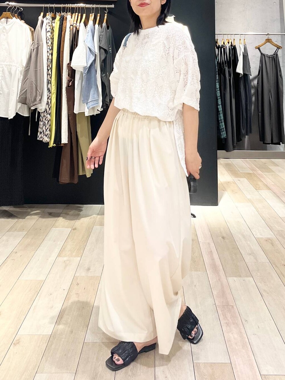 ブルー系のショルダーバッグ、ホワイト系のスラックス、ホワイト系のTシャツ/カットソーを着用したレディースの夏コーディネートの5枚目の写真