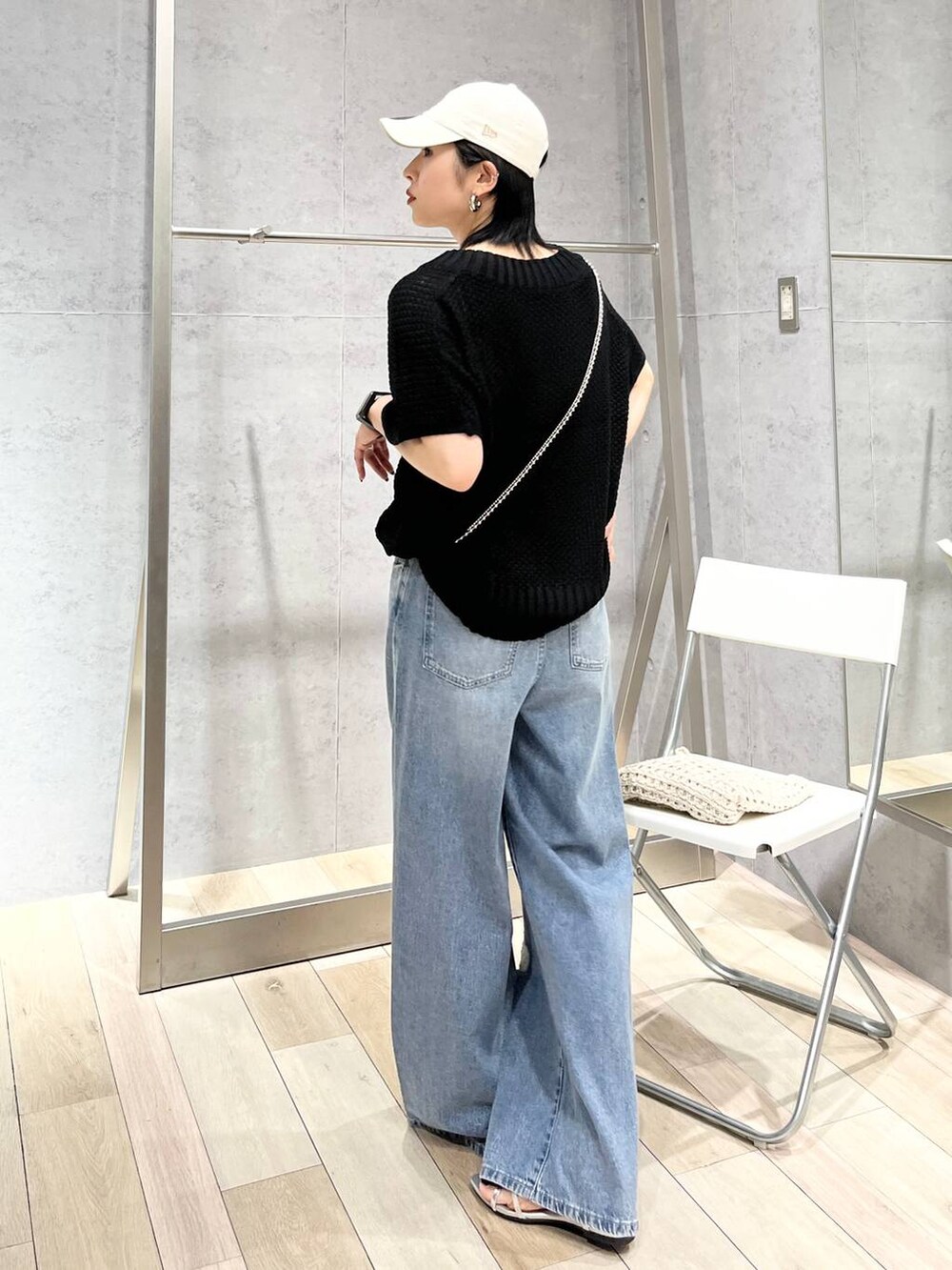 シルバー系のサンダル、ブラック系のニット/セーター、ブルー系のデニムパンツを着用したレディースの春コーディネートの5枚目の写真