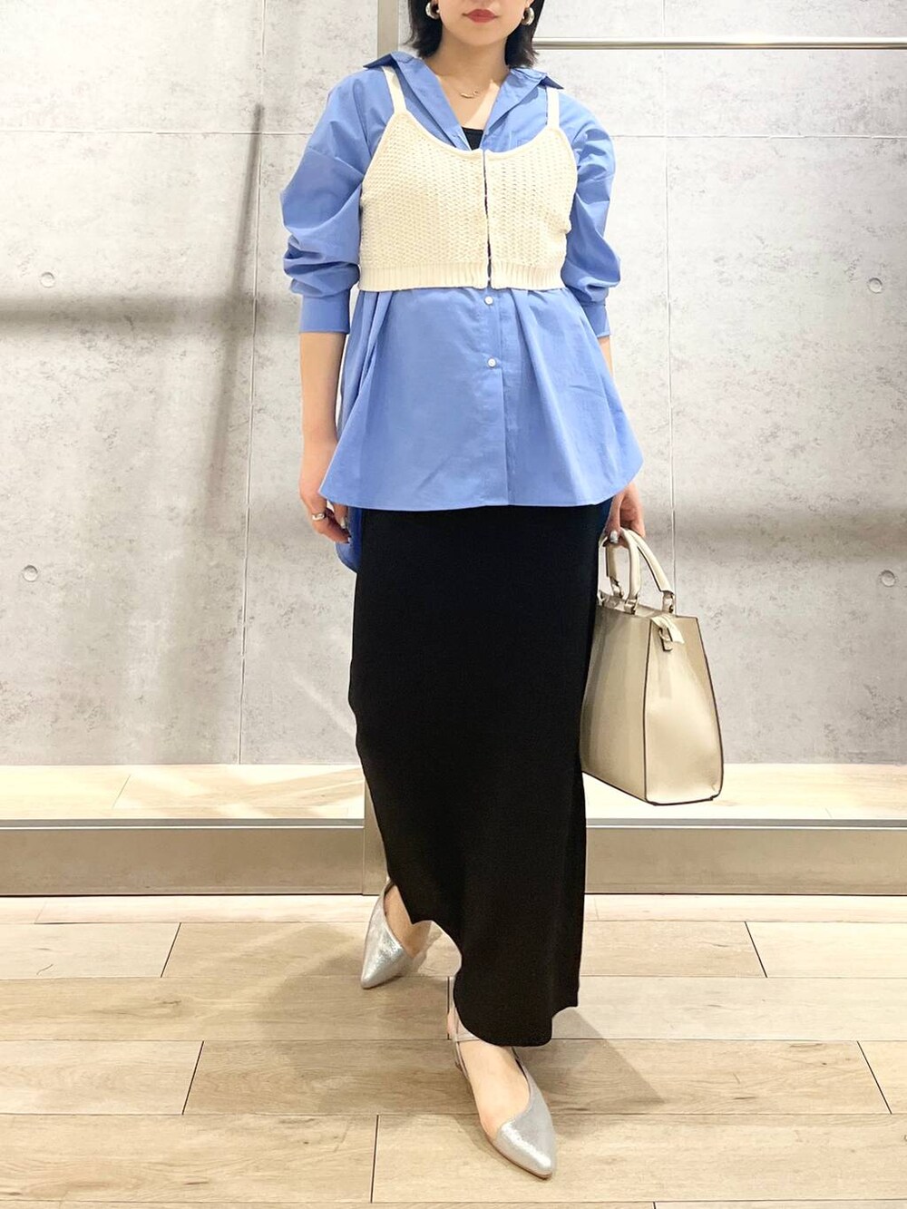 ブルー系のシャツ/ブラウス、ブラック系のスカート、ホワイト系のショルダーバッグを着用したレディースの冬コーディネートの8枚目の写真