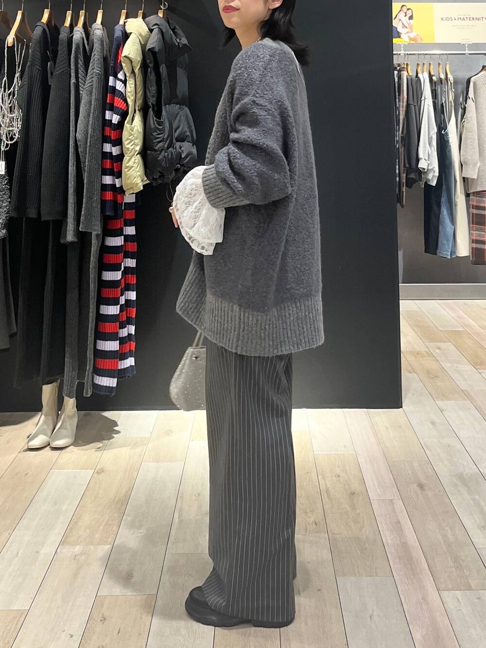 シルバー系のショルダーバッグ、ブラック系のブーツ、ホワイト系のTシャツ/カットソーを着用したレディースの秋コーディネートの3枚目の写真