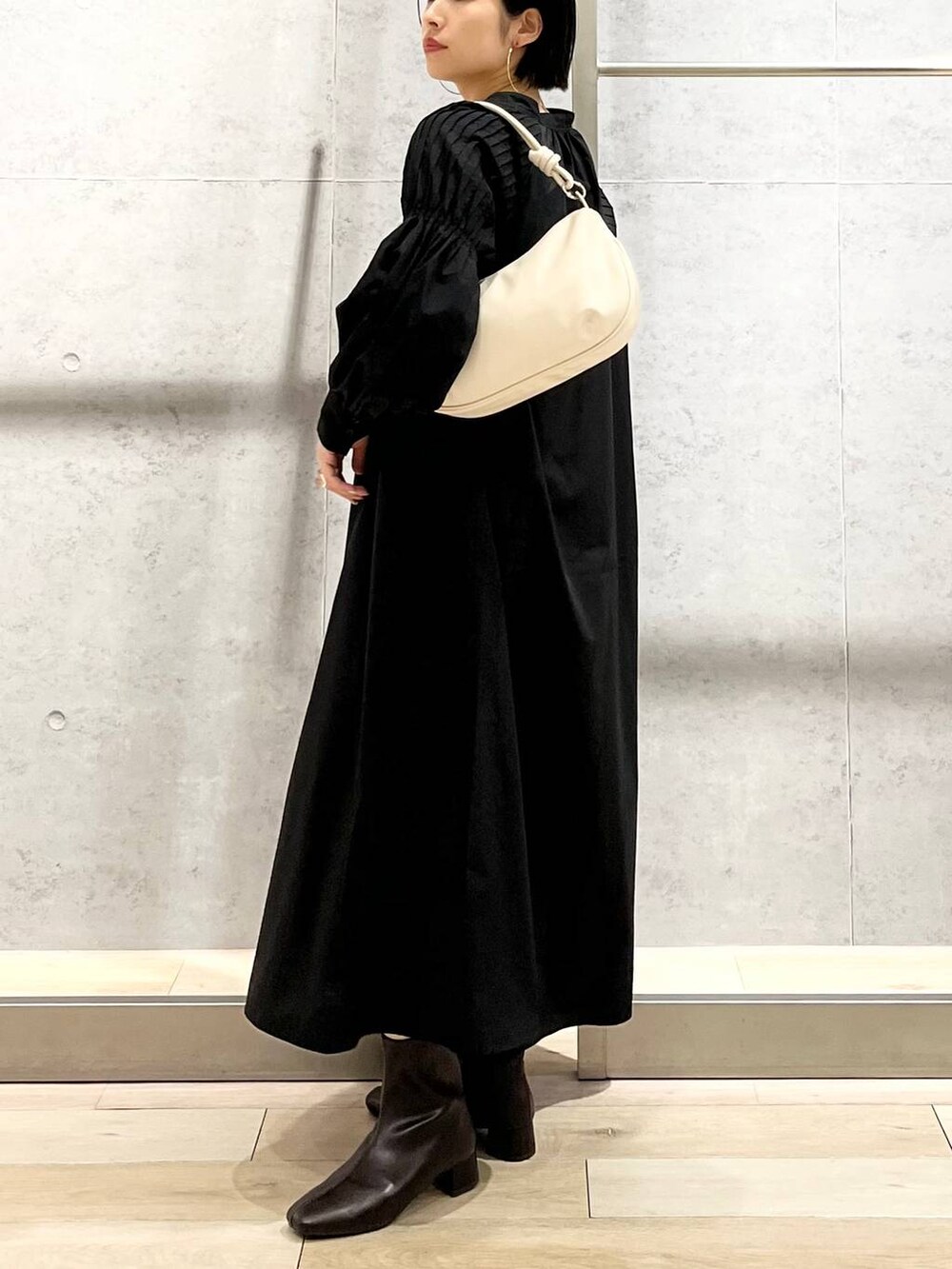 ホワイト系のキャミソール、ブラック系のワンピース、ホワイト系のショルダーバッグを着用したレディースの秋コーディネートの4枚目の写真