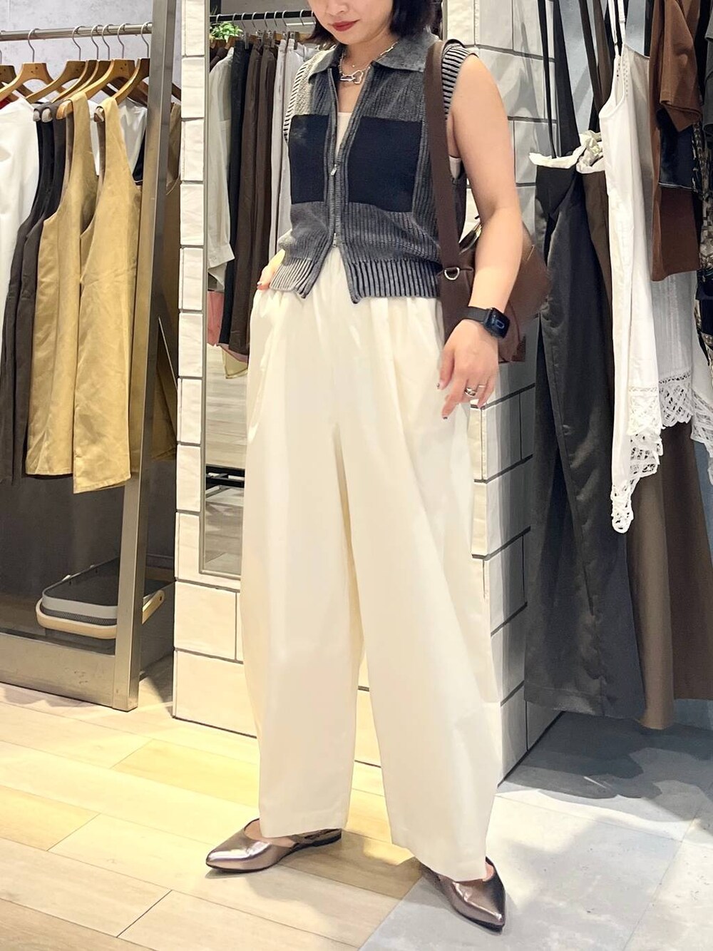 ブラウン系のショルダーバッグ、ホワイト系のタンクトップ、シルバー系のキーホルダーを着用したレディースの夏コーディネートの7枚目の写真