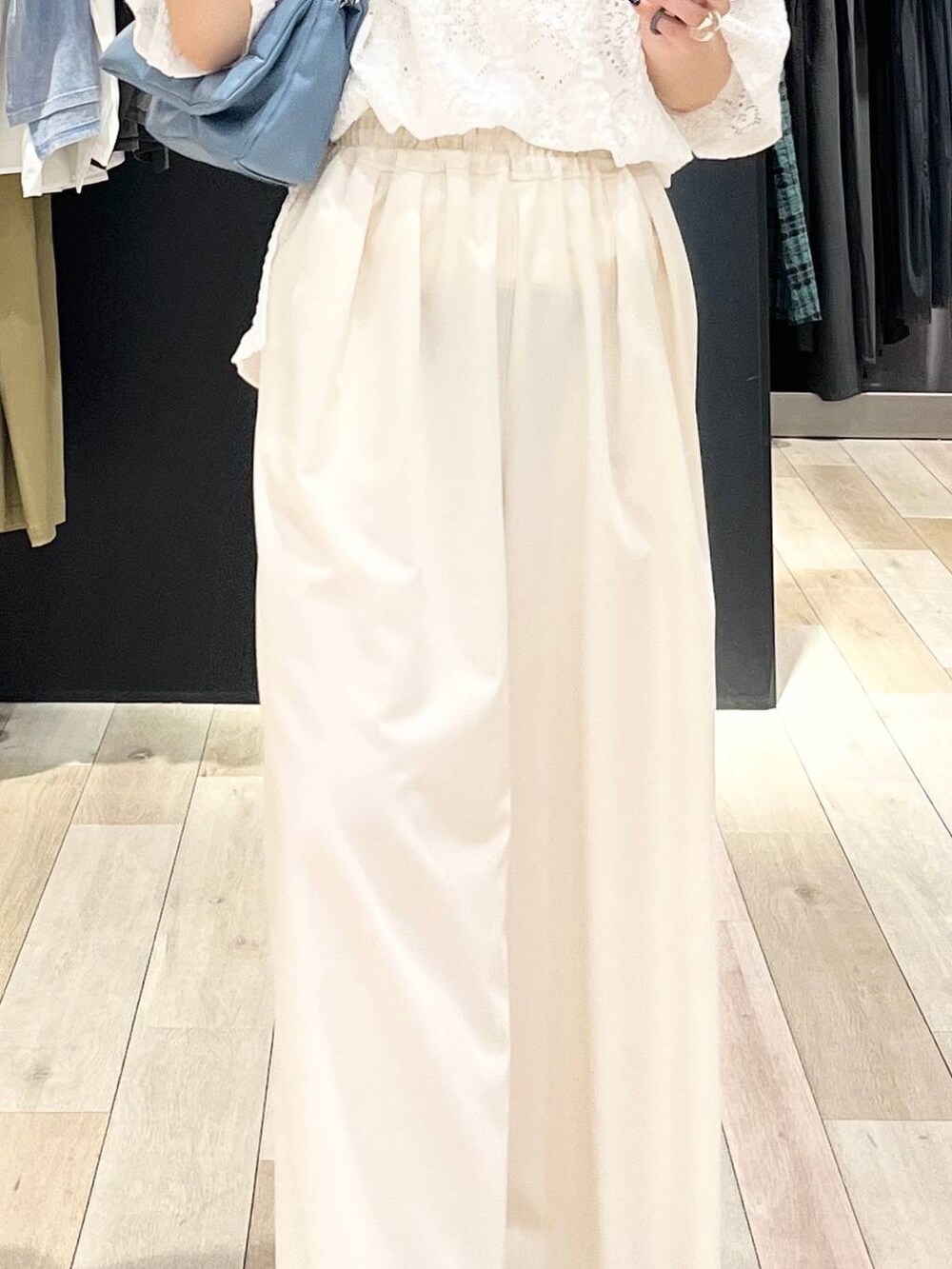 ブルー系のショルダーバッグ、ホワイト系のスラックス、ホワイト系のTシャツ/カットソーを着用したレディースの夏コーディネートの6枚目の写真