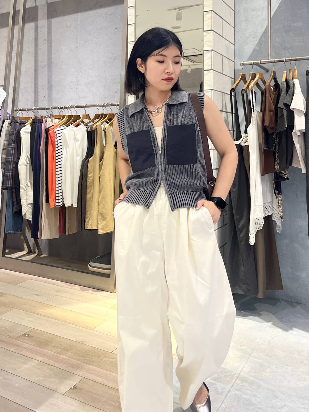 ブラウン系のショルダーバッグ、ホワイト系のタンクトップ、シルバー系のキーホルダーを着用したレディースの夏コーディネートの2枚目の写真