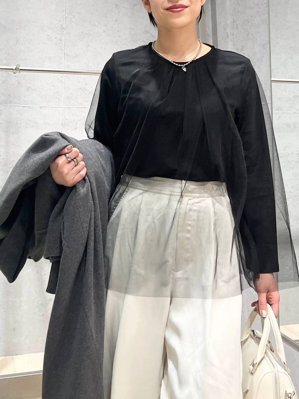 グレー系のその他アウター、ブラック系のTシャツ/カットソー、ブラック系のパンプスを着用したレディースの冬コーディネートの3枚目の写真