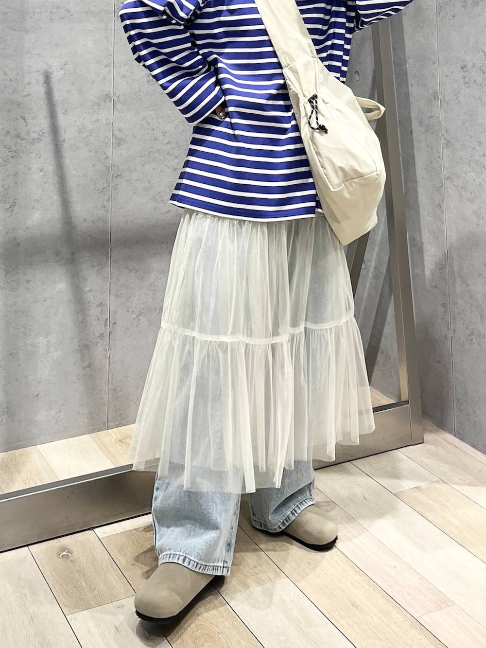 ホワイト系のスカート、パープル系のTシャツ/カットソー、ブルー系のデニムパンツを着用したレディースの冬コーディネートの9枚目の写真