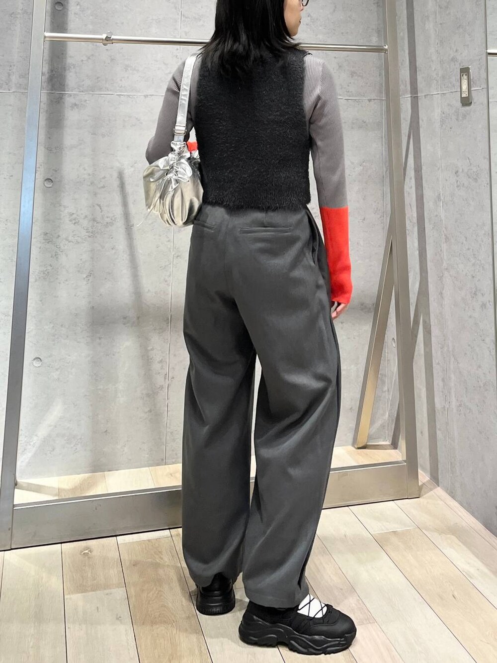 グレー系のニット/セーター、グレー系のベスト、グレー系のショルダーバッグを着用したレディースの冬コーディネートの4枚目の写真