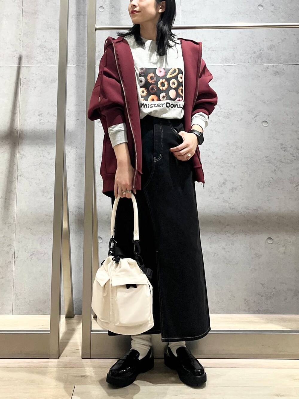 ホワイト系のショルダーバッグ、レッド系のパーカー、ブラック系のデニムスカートを着用したレディースの冬コーディネートの4枚目の写真