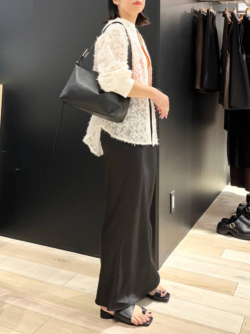 ホワイト系のタンクトップ、ブラック系のスカート、ブラック系のサンダルを着用したレディースの夏コーディネートの2枚目の写真