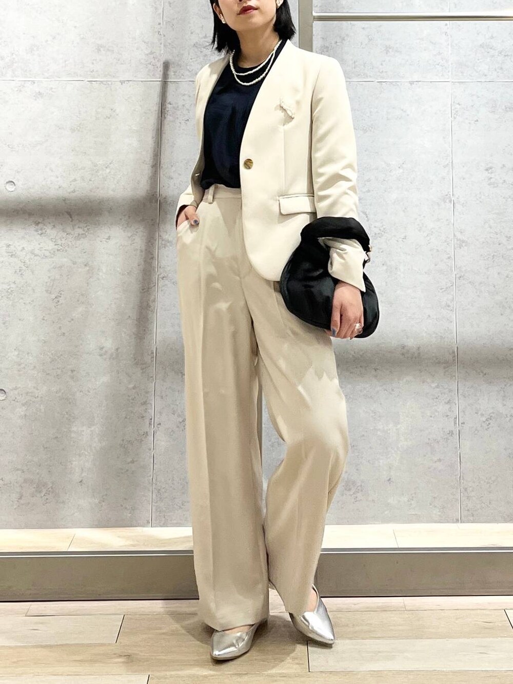 ブラック系のハンドバッグ、ブルー系のシャツ/ブラウス、ホワイト系のノーカラージャケットを着用したレディースの冬コーディネートの2枚目の写真