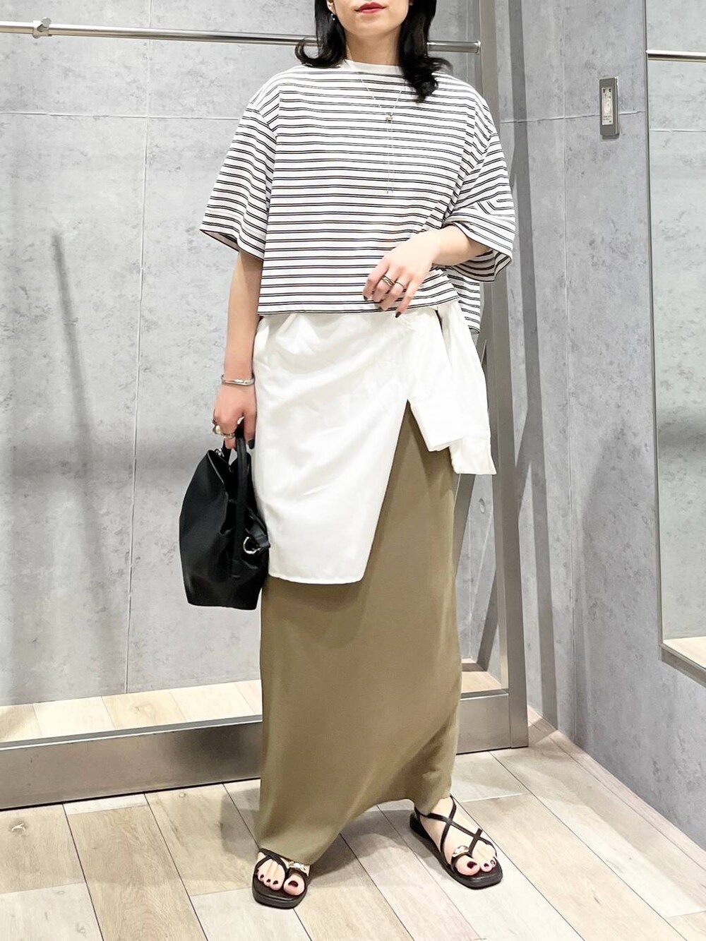 グリーン系のスカート、ホワイト系のTシャツ/カットソー、ホワイト系のシャツ/ブラウスを着用したレディースの春コーディネートの2枚目の写真