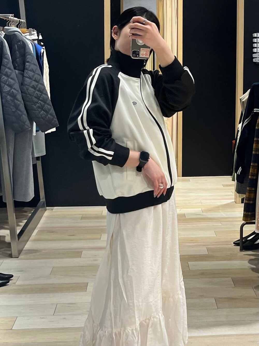 ホワイト系のスカート、ブラック系のブーツ、ブルー系のTシャツ/カットソーを着用したレディースの冬コーディネートの2枚目の写真