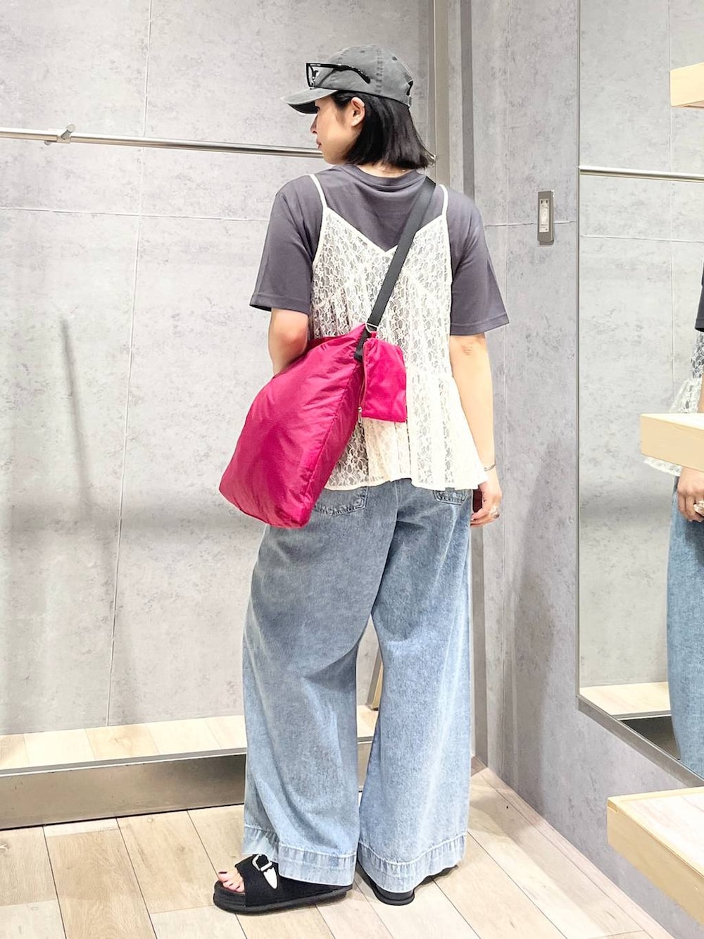 ブルー系のデニムパンツ、ブラック系のサンダル、ピンク系のショルダーバッグを着用したレディースの夏コーディネートの5枚目の写真