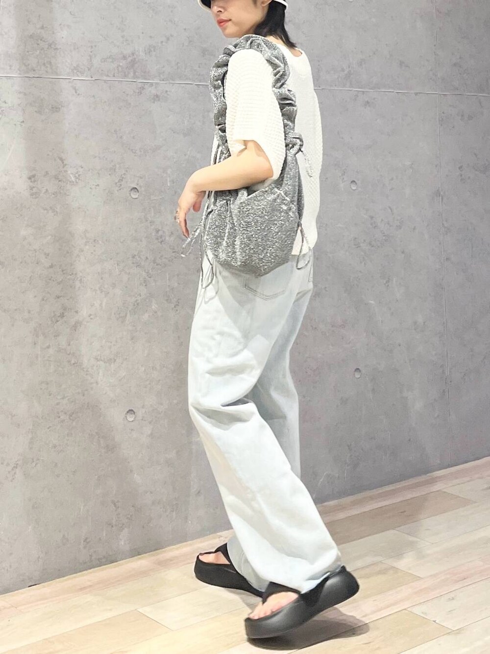 ブラック系のサンダル、ブルー系のデニムパンツ、ホワイト系のニット/セーターを着用したレディースの夏コーディネートの3枚目の写真