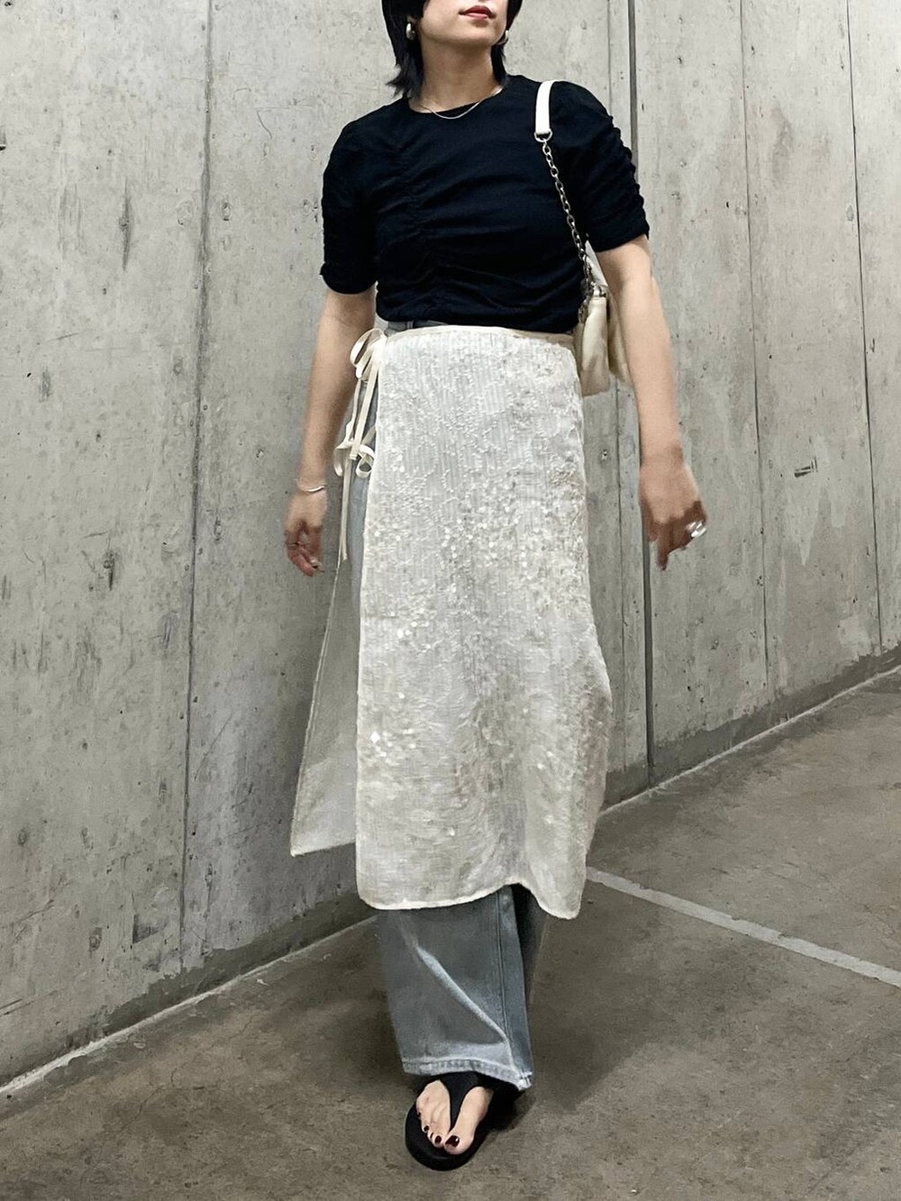 ホワイト系のショルダーバッグ、ブルー系のデニムパンツ、ブラック系のTシャツ/カットソーを着用したレディースの春コーディネートの3枚目の写真