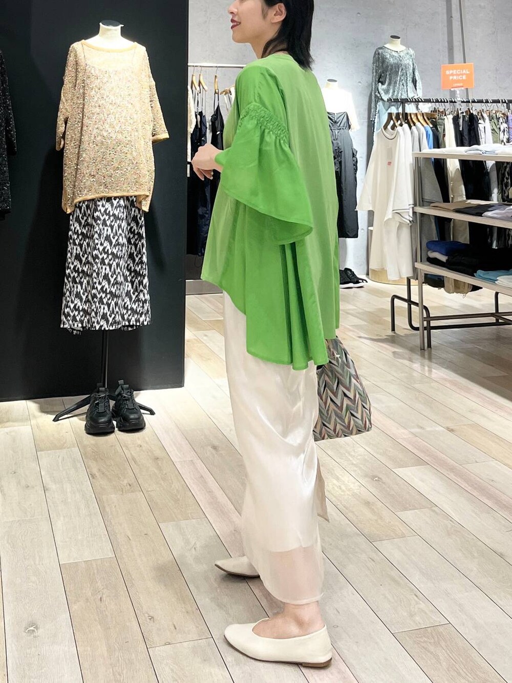 ホワイト系のハンドバッグ、ホワイト系のパンプス、ホワイト系のスカートを着用したレディースの春コーディネートの2枚目の写真