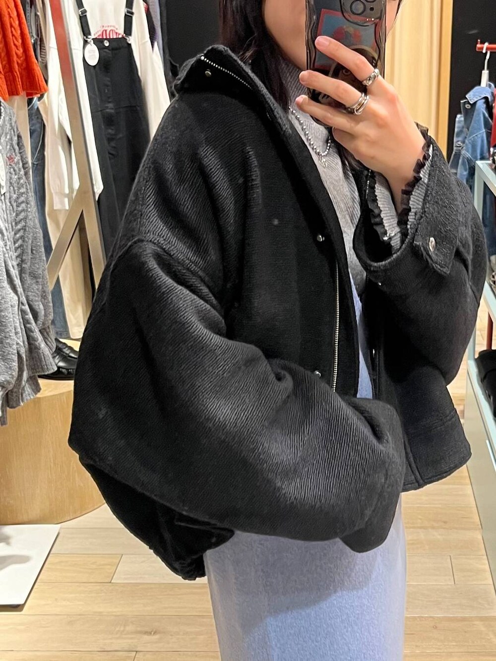 ブラック系のブルゾン、ブルー系のワンピース、ブラック系のブーツを着用したレディースの秋コーディネートの8枚目の写真