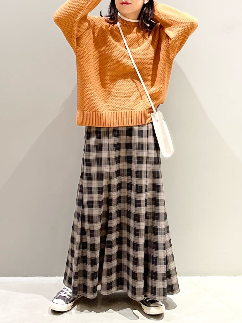 ブラック系のスカート、グレー系のスニーカー、ホワイト系のショルダーバッグを着用したレディースの冬コーディネートの4枚目の写真