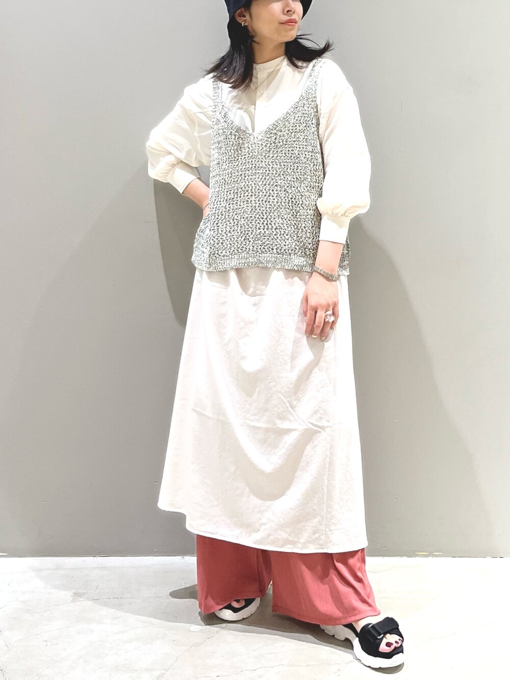 ピンク系のパンツ、ブラック系のサンダル、ブラック系のトップスを着用したレディースの秋コーディネートの2枚目の写真