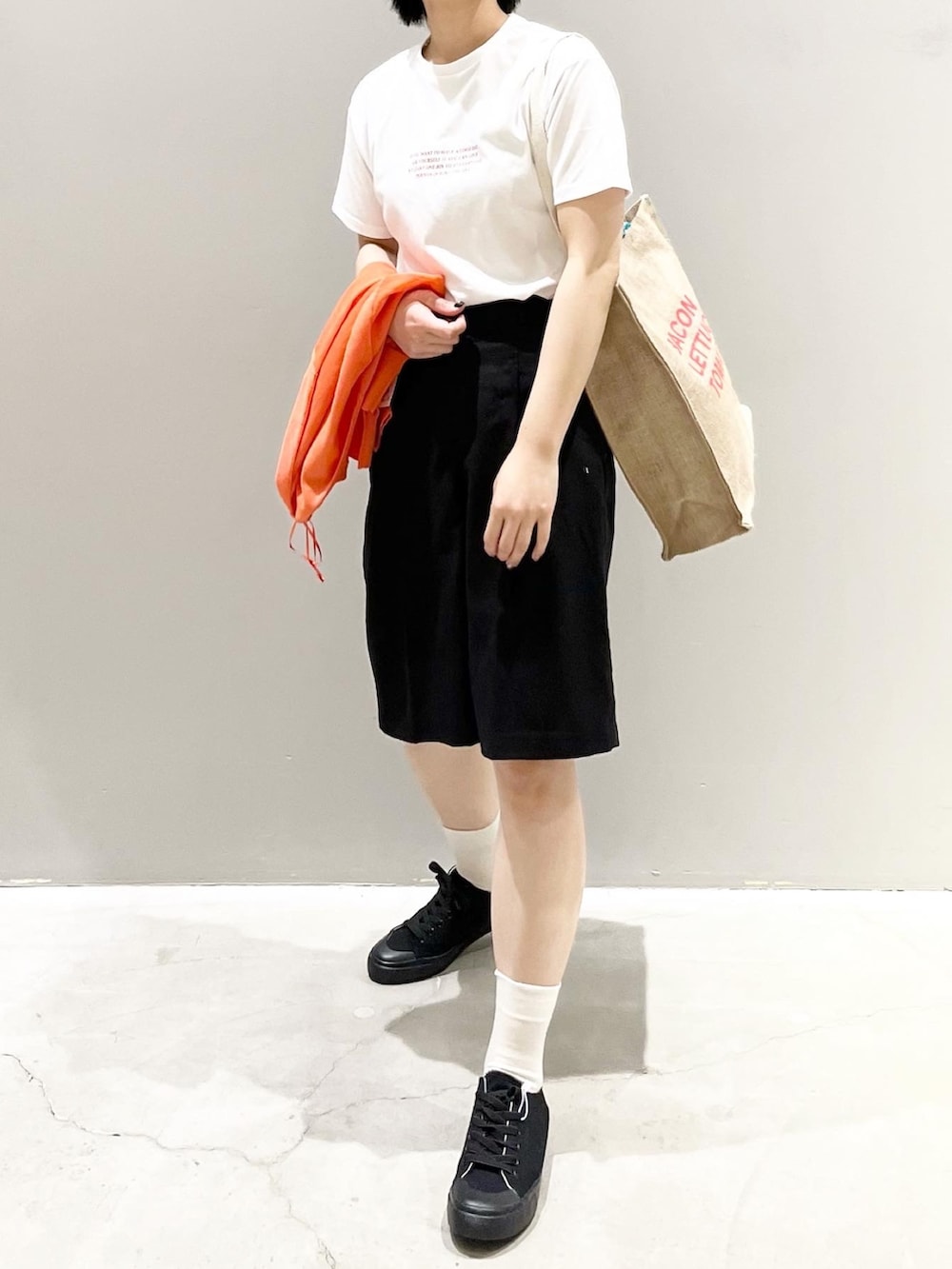 ブラック系のその他パンツ、ブラック系のスニーカー、オレンジ系のトートバッグを着用したレディースの夏コーディネートの6枚目の写真