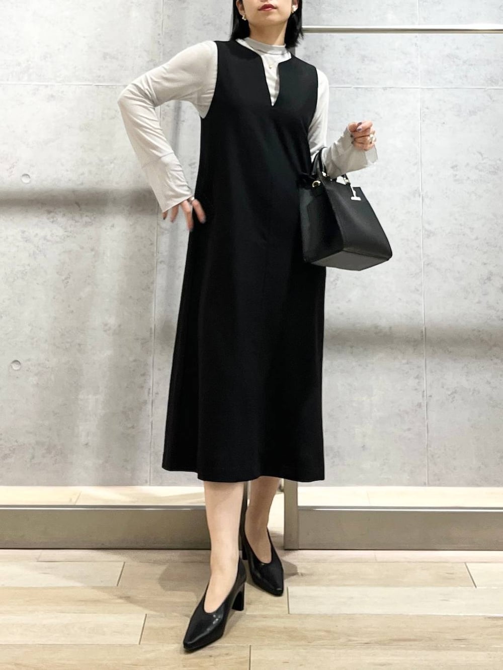 ブラック系のパンプス、グレー系のTシャツ/カットソー、ブラック系のショルダーバッグを着用したレディースの冬コーディネートの3枚目の写真