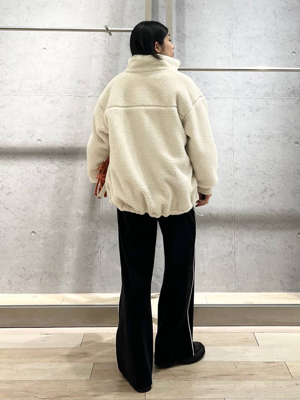 ブラック系のブーツ、ホワイト系のニット/セーター、ホワイト系のその他アウターを着用したレディースの冬コーディネートの4枚目の写真