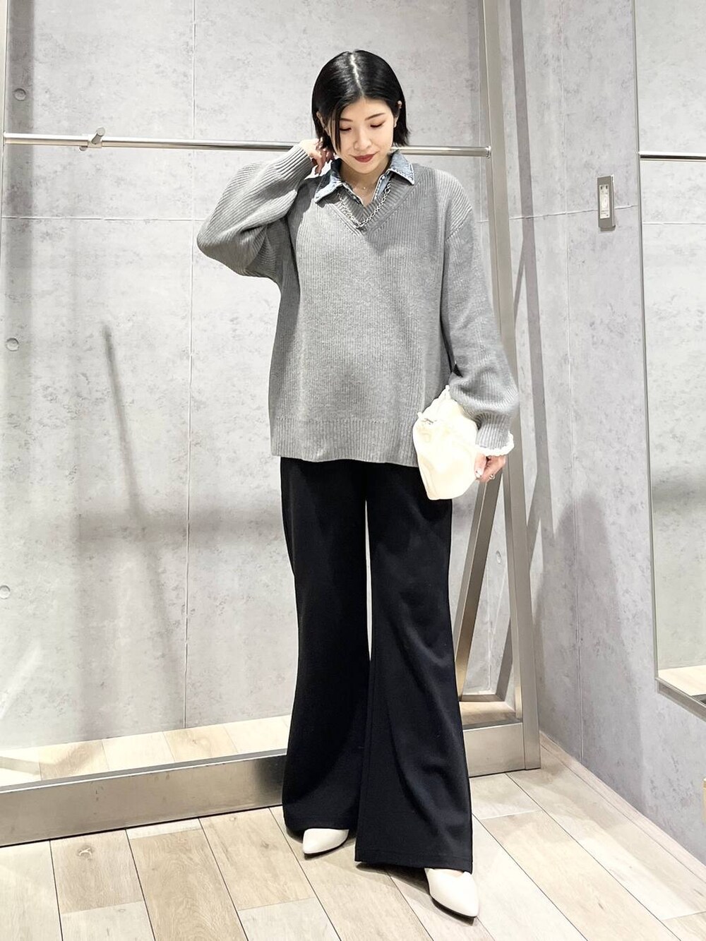 ホワイト系のパンプス、ホワイト系のショルダーバッグ、ブラック系のその他パンツを着用したレディースの冬コーディネートの2枚目の写真