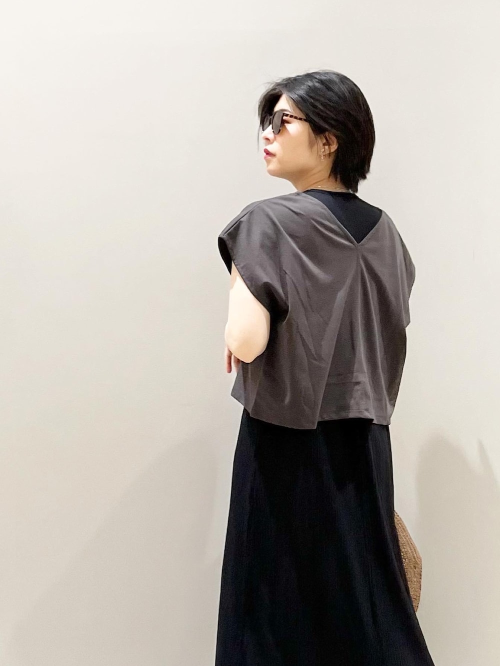 ベージュ系のサンダル、ブラック系のワンピース、ブラウン系のハットを着用したレディースの春コーディネートの5枚目の写真