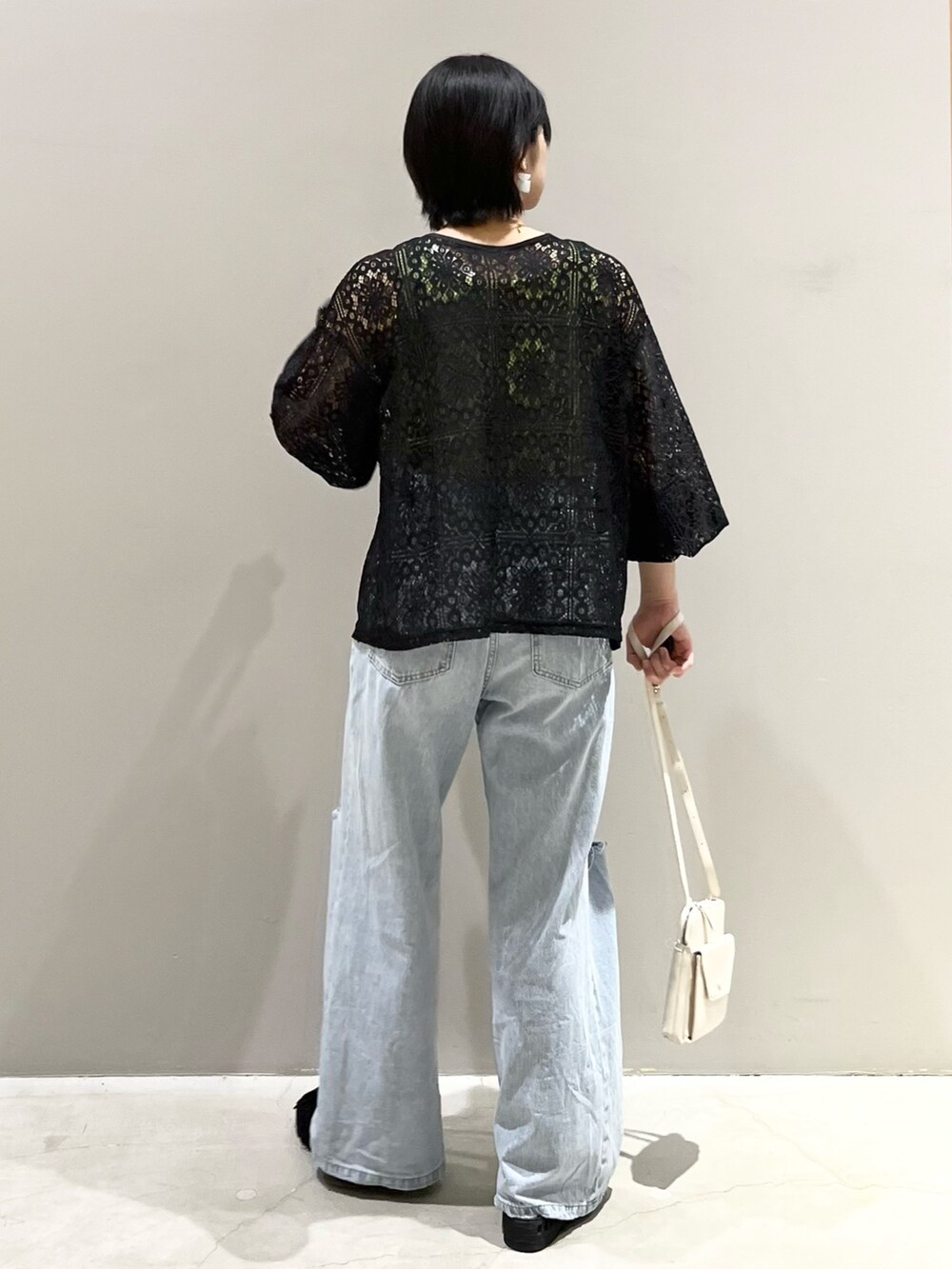 ブラック系のシャツ/ブラウス、ブルー系のデニムパンツ、ブラック系のサンダルを着用したレディースの秋コーディネートの4枚目の写真