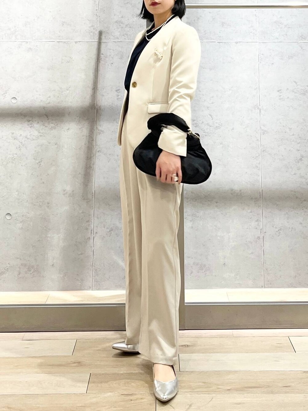 ブラック系のハンドバッグ、ブルー系のシャツ/ブラウス、ホワイト系のノーカラージャケットを着用したレディースの冬コーディネートの5枚目の写真