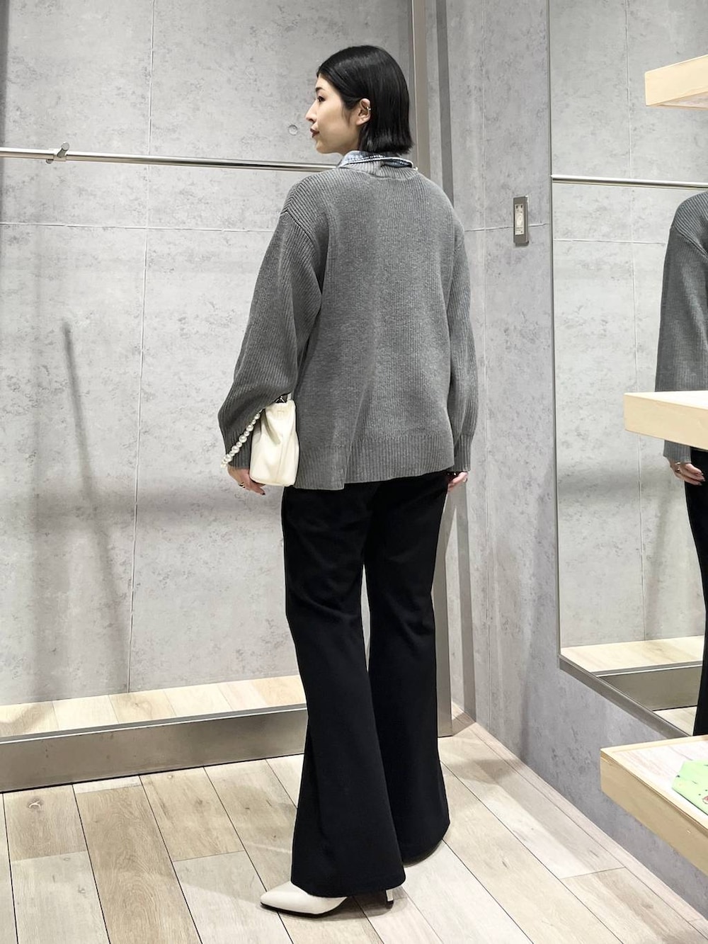 ホワイト系のパンプス、ホワイト系のショルダーバッグ、ブラック系のその他パンツを着用したレディースの冬コーディネートの3枚目の写真