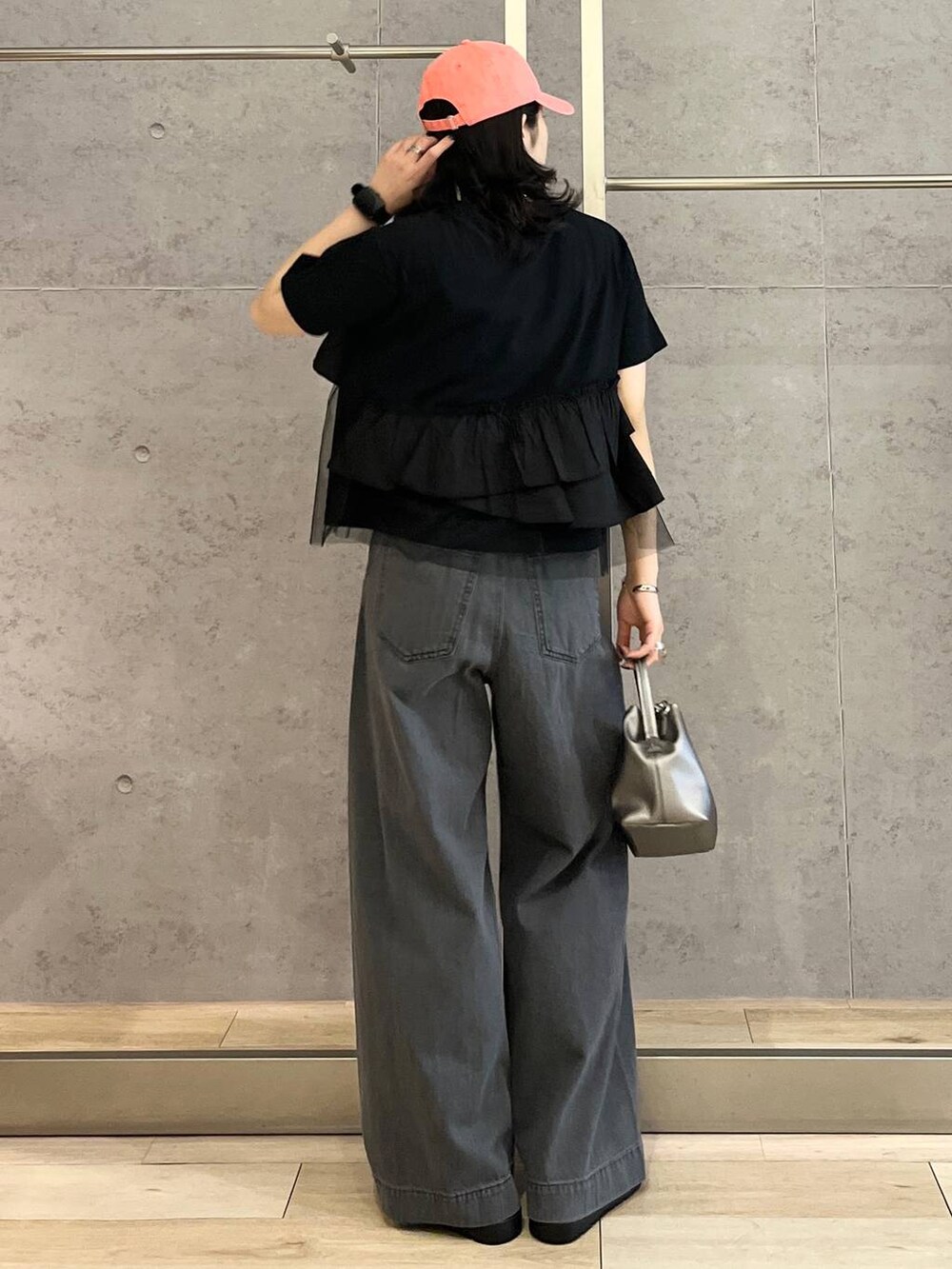 シルバー系のサンダル、ブラック系のデニムパンツ、ホワイト系のショルダーバッグを着用したレディースの春コーディネートの4枚目の写真