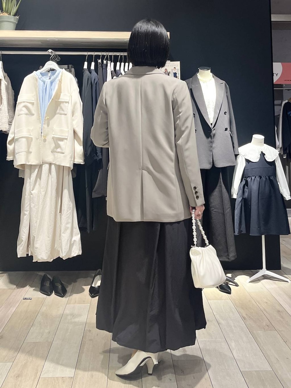 ブラウン系のテーラードジャケット、ブラック系のスカート、ブラック系のシャツ/ブラウスを着用したレディースの冬コーディネートの4枚目の写真