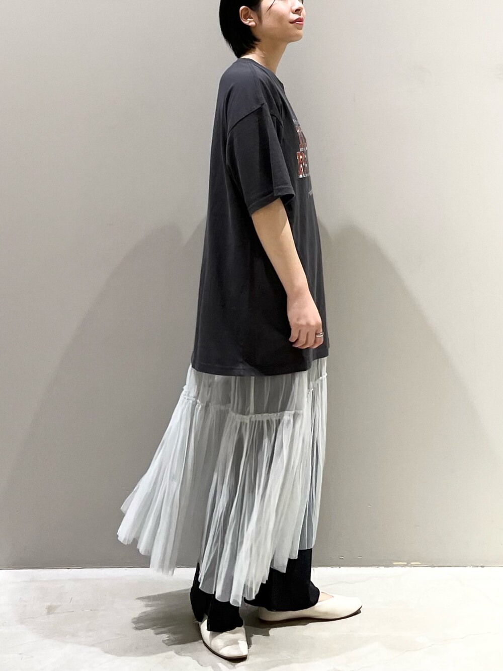 ブラック系のデニムパンツ、グレー系のスカート、ゴールド系のハンドバッグを着用したレディースの夏コーディネートの7枚目の写真