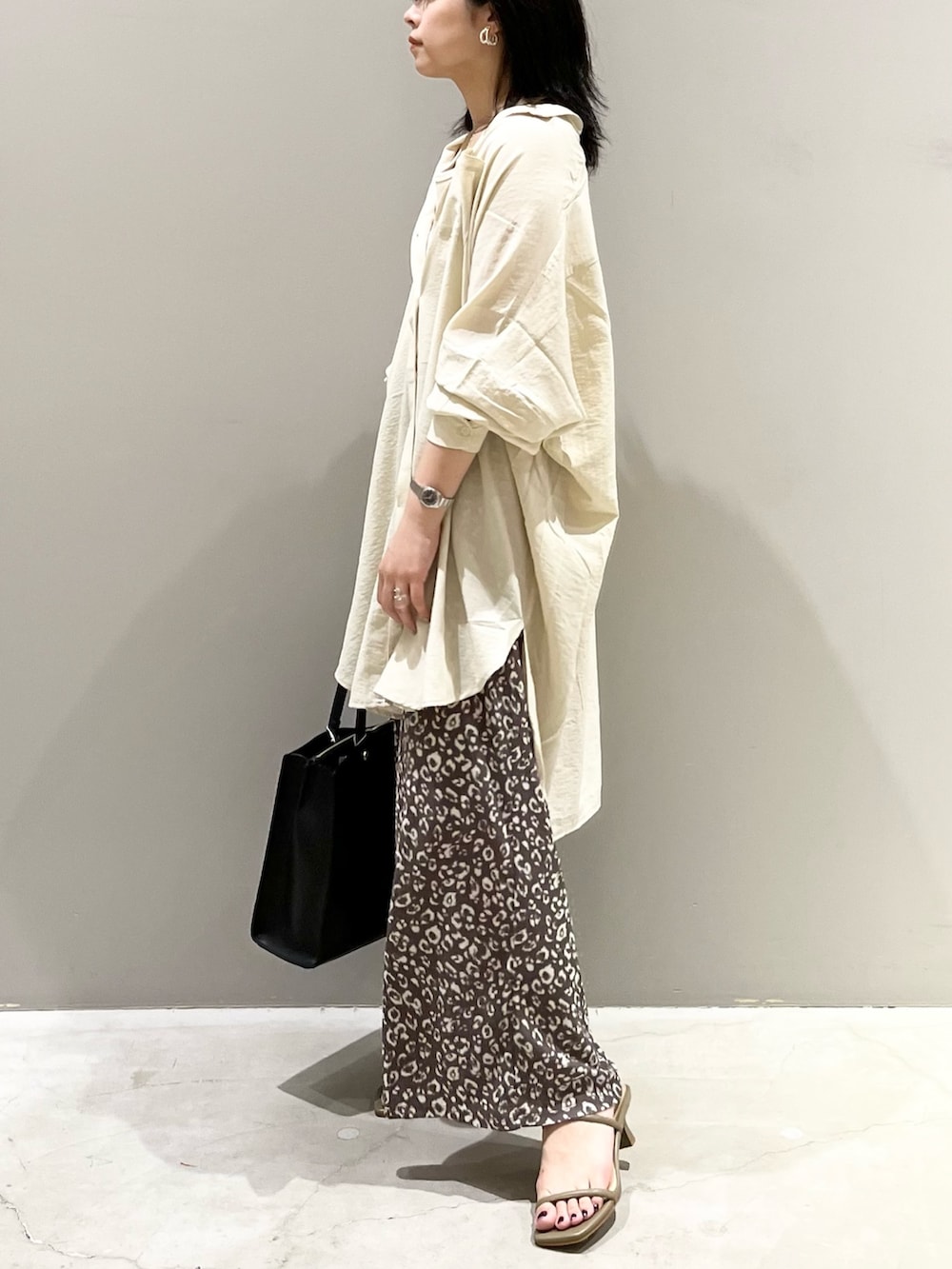 ブラック系のトートバッグ、ブラウン系のサンダル、ホワイト系のシャツ/ブラウスを着用したレディースの秋コーディネートの4枚目の写真